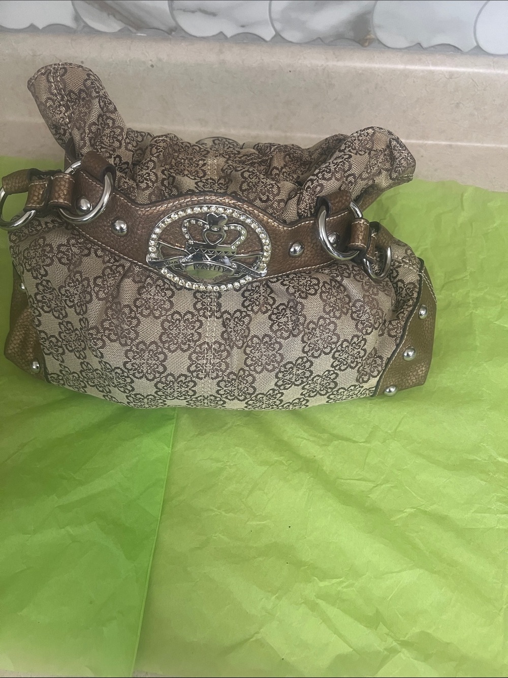 Brown Patterned Kathy Van Zeeland Shoulder Bag with Decorative Crest Accent